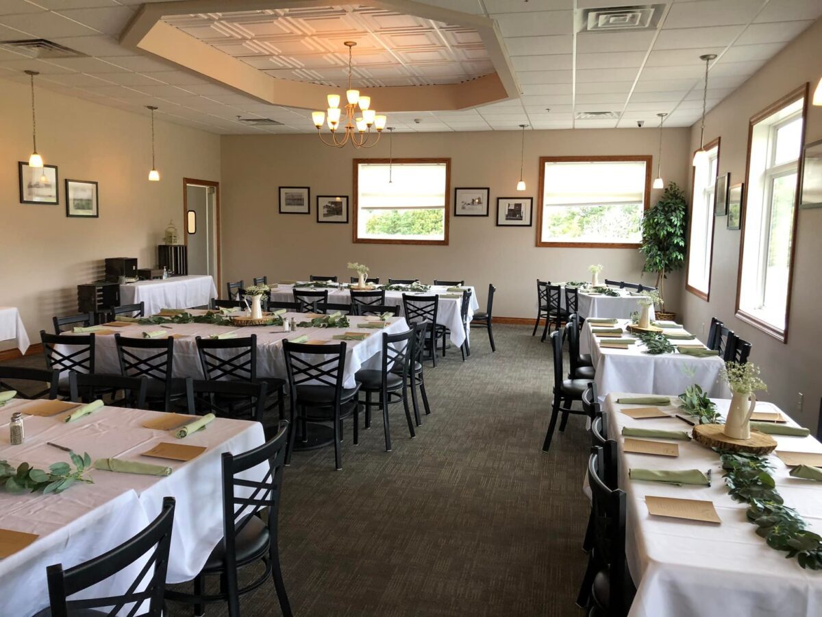 interior of 10th Hole set up with tables, chairs, tablecloths.
