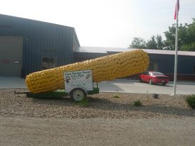 Large ear of corn (made out of milk jugs and painted yellow) parked outside the Community Center