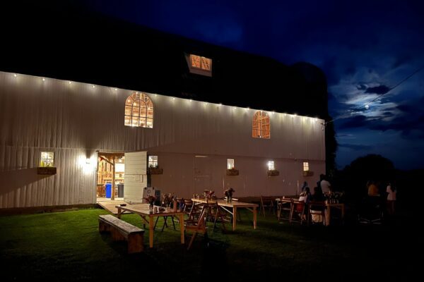 Nighttime view of Tailwind Acres barn and tables set up outside